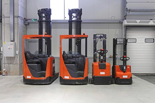 forklifts handling heavy equipment at a manufacturing facility